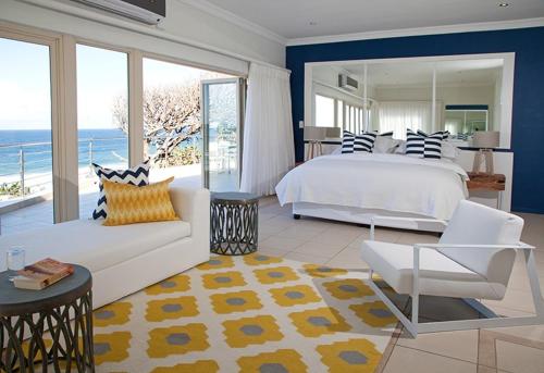 a large bedroom with a bed and a couch and a view at Rockshandy Beachhouse in Southbroom