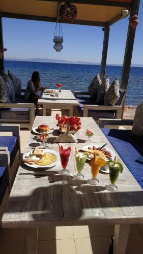 a table with plates of food on top of the ocean at Shams Hotel & Dive Centre in Dahab