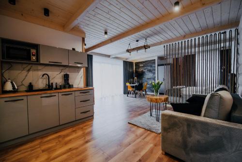 a kitchen and living room with a couch and a table at Apartamenty Oliwia Jacuzzi & Sauna in Małe Ciche