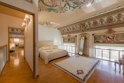 a bedroom with a bed and a painting on the wall at EXCEPTIONNEL !!! VENEZ SEJOURNER DANS LES 3 SUITES D'UN AUTHENTIQUE ANCIEN PALACE DE LA "BELLE EPOQUE" de 1874 !!! UNIQUE !!! in Menton