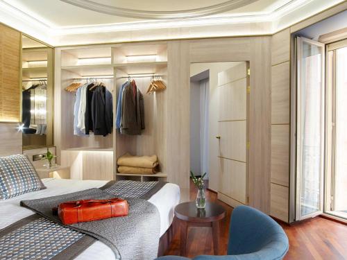 a bedroom with a bed and a chair and a mirror at Preciados in Madrid