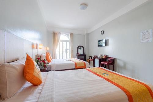 a hotel room with two beds and a window at Galaxy Hotel Phu Quoc in Phu Quoc