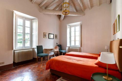 a bedroom with a bed and a table and chairs at Appartamento nel Parco di Villa Erba in Cernobbio