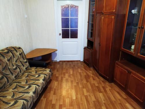 ein Wohnzimmer mit einem Sofa, einem Tisch und einer Tür in der Unterkunft Прокофьева 24б Уютная посуточная квартира in Sumy