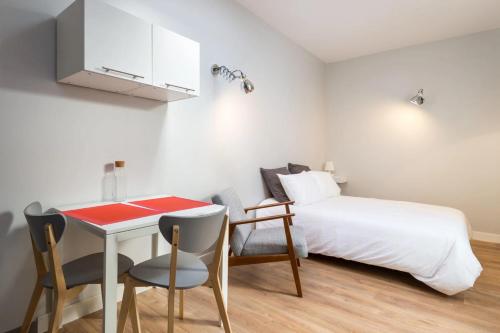 1 dormitorio con 1 cama, mesa y sillas en DIFY Jaboulay - Jean Macé en Lyon