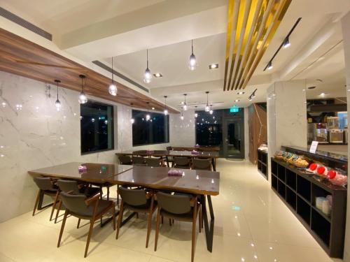 a dining room with tables and chairs and a kitchen at Love Tong in Jiaoxi