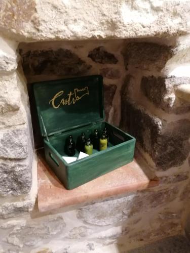 a green box sitting on a stone wall with three bottles at Castro Rooms Chios in Chios