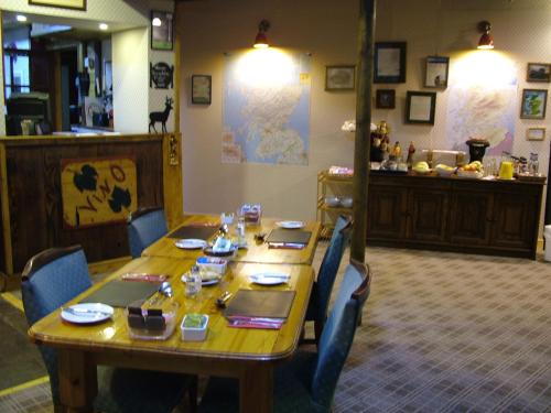 a wooden table with chairs around it in a room at The Steading Highland Glen Lodge in Drumnadrochit