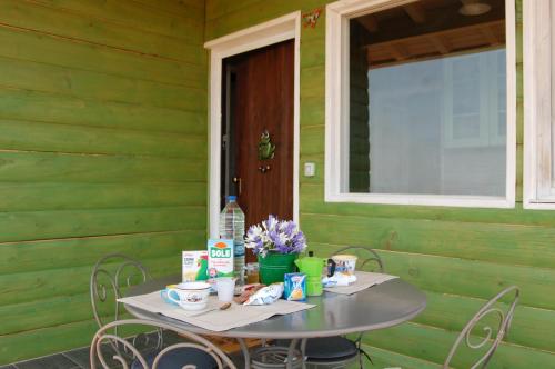 a table and chairs in front of a green wall at Mandorleo in Belpasso