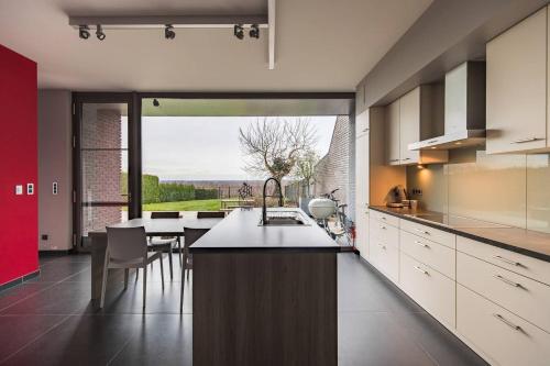 a kitchen with a counter and a large window at La Maison de Marie in Borgloon