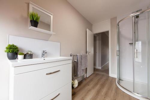 a white bathroom with a sink and a shower at Large House - Contractors & Families & Private Parking in Northampton