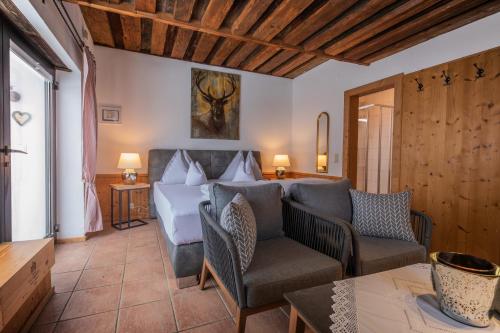 a bedroom with a bed and chairs in a room at Chalet Stubai inklusive Stubai Super Card in Fulpmes