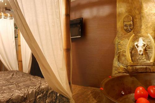 a room with a bed and a tub with a statue at Posada la Leyenda in Santillana del Mar