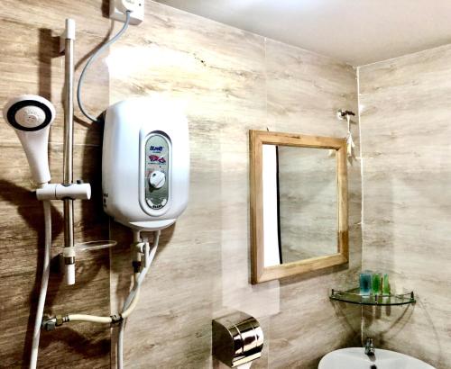 ein Bad mit einer Dusche, einem WC und einem Spiegel in der Unterkunft Am Transit Inn in Kuala Terengganu