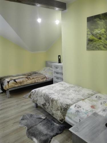 a bedroom with two beds and a dresser in it at Gościna U kowala in Lachowice