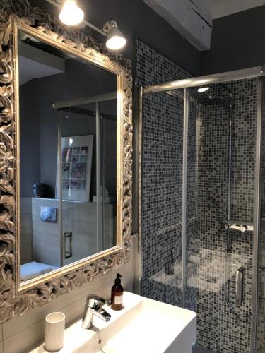 a bathroom with a mirror and a sink and a shower at Casa Bacìomari in Bologna