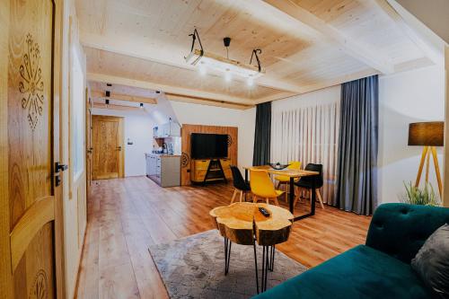 a living room with a couch and a table at Apartamenty Oliwia Jacuzzi & Sauna in Małe Ciche