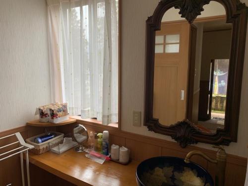 a bathroom counter with a sink and a mirror at Yufuin-Sanso Waremokou in Yufuin