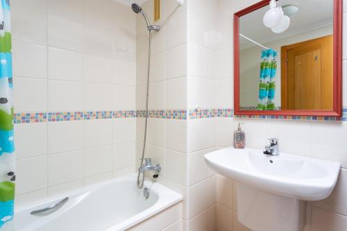 Un baño blanco con lavabo y ducha. en Home2Book La Tejita Beach and Pool, en Granadilla de Abona