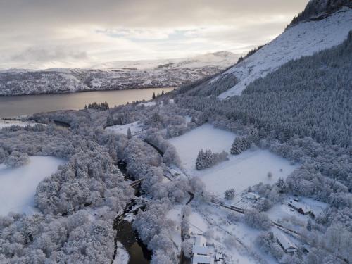 an aerial view of a snow covered mountain and a lake at Lann Dearg Studios in Invermoriston
