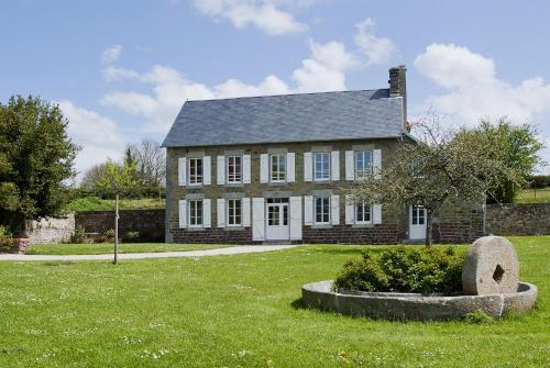 una antigua casa de ladrillo con un gran patio de césped en Manoir du Mesnil de Bas en Bréhal