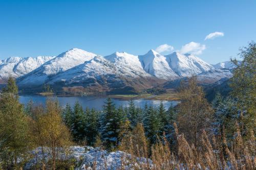 a mountain view of a lake with snow covered mountains at Lann Dearg Studios in Invermoriston