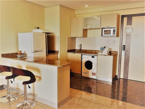 a kitchen with a washer and dryer in it at Best Western Plus Mahboula in Kuwait