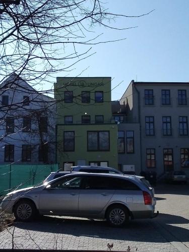 a car parked in a parking lot in front of a building at Hotel Ungar in Svitavy