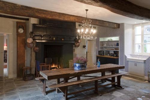 un salon avec une table et une cheminée dans l'établissement Manoir du Mesnil de Bas, à Bréhal