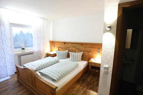 a bedroom with a bed with two pillows and a window at Landhaus Schlossberg in Medebach