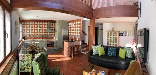 a living room with a couch and a kitchen at La Casa De La Abuela in Ortigosa del Monte