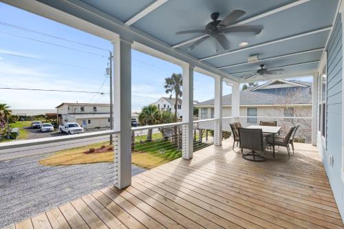 a screened porch with a table and a ceiling fan at LaiDDback in Folly Beach