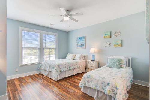 a bedroom with two beds and a ceiling fan at LaiDDback in Folly Beach