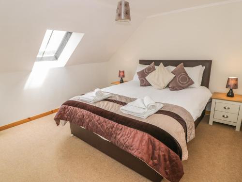 a bedroom with a bed with two towels on it at The Dairy in Newton Stewart