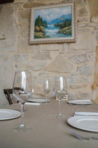 a table with wine glasses and plates on it at Posada Condado de la Mota in Mogro