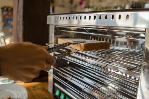 a person is putting a piece of food in an oven at Posada Condado de la Mota in Mogro