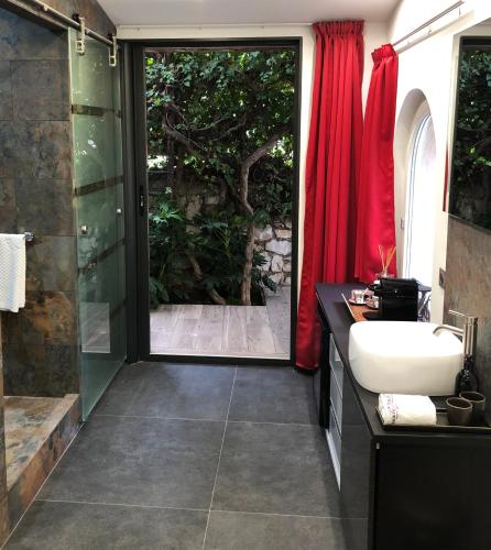 a bathroom with a shower and a sink and a glass door at THE ADDRESS CASSIS in Cassis
