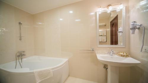 文尼察的住宿－菲尼克斯酒店，白色的浴室设有浴缸和水槽。