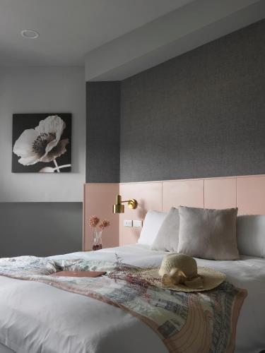 a bedroom with a large bed with a hat on it at Mr.Mantter in Taichung
