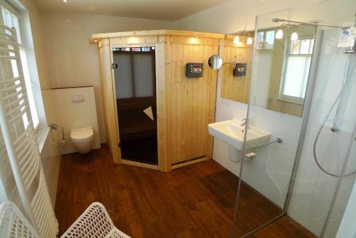 a bathroom with a shower and a sink and a toilet at Haus STRANDHAFER WF-07 (rechts) in Wustrow
