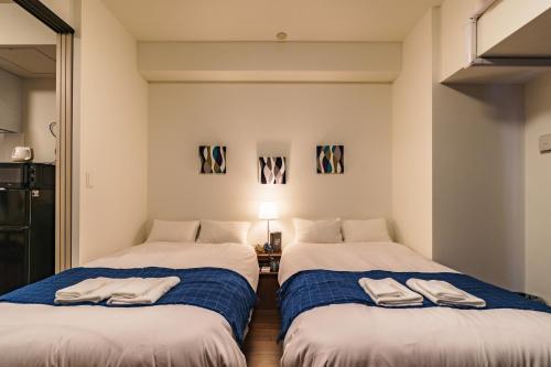 two beds sitting next to each other in a room at IKIDANE Residential Hotel SHIMANOUCHI in Osaka