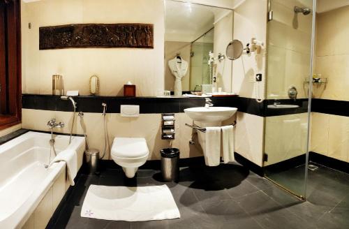 a bathroom with a tub and a sink and a toilet at The Zuri Kumarakom Kerala Resort & Spa in Kumarakom