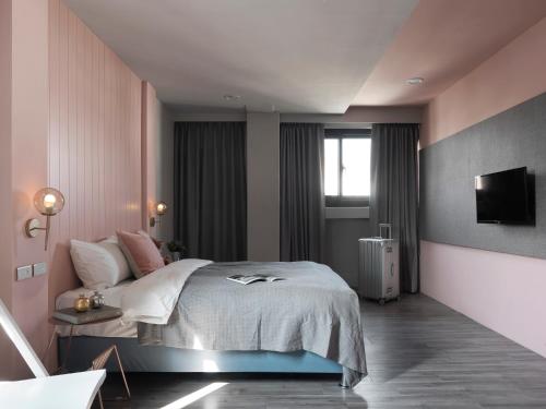 a bedroom with a bed and a tv on a wall at Mr.Mantter in Taichung