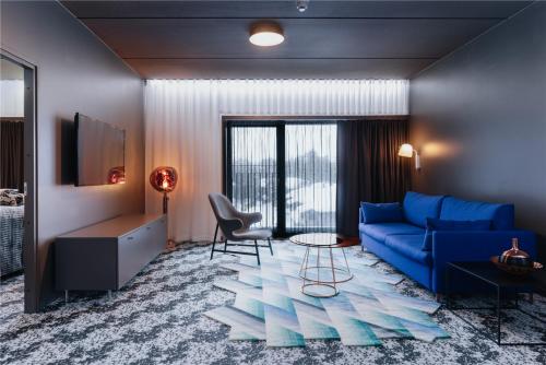 a living room with a blue couch and a table at Design Hotel Levi in Levi