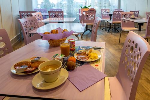 een tafel met ontbijtproducten en een kopje koffie bij Hôtel - Restaurant Saint Jacques in Blois