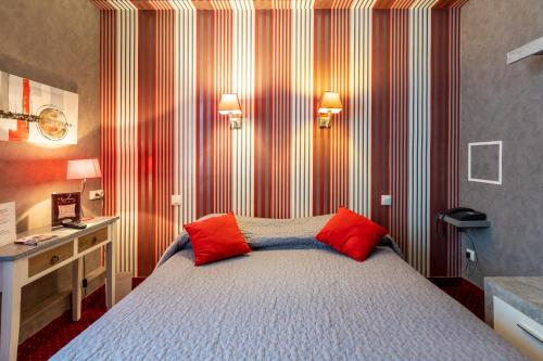 a bedroom with a bed with two red pillows at Hôtel - Restaurant Saint Jacques in Blois