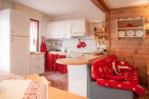 a kitchen with a counter and a red chair in it at Casa Fiore CIPAT 22038 in Canale San Bovo