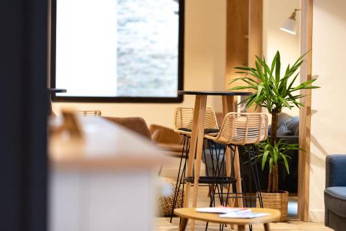 a room with chairs and a table and plants at Hôtel du Beffroi Gravelines Dunkerque in Gravelines