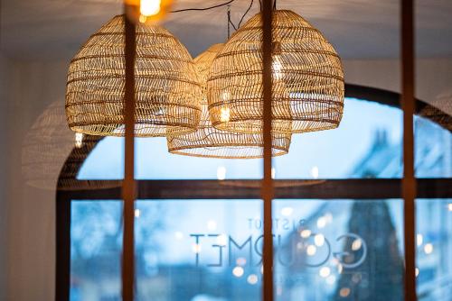 a chandelier hanging in front of a window at Hôtel du Beffroi Gravelines Dunkerque in Gravelines