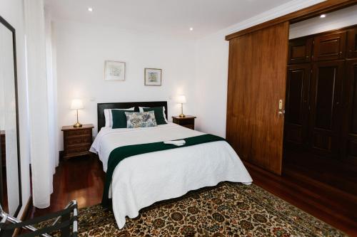 a bedroom with a large bed and a wooden door at Casa da Calçada in Guimarães